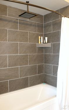 a white bath tub sitting next to a shower head in a bathroom under a faucet