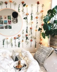 a bedroom with flowers on the wall and a laptop computer sitting on top of a bed