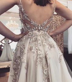 the back of a woman's wedding dress in front of a mirror