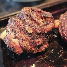 two steaks sitting on top of a pan covered in seasoning next to each other