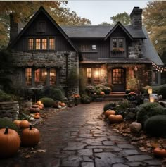 a house with pumpkins in front of it and lights on the windows at night