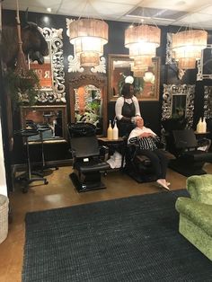 a woman getting her hair done in a salon with two chairs and mirrors on the wall