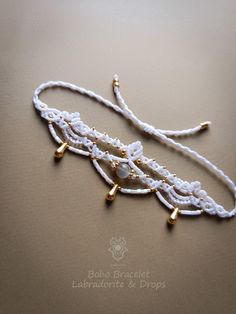 Macrame bohemian armband with brass charms. Polyester waxed thread: Linhasita frozen white. Macrame beaded design:  Length: 12,50 cm or 4,92 inches. Width: 3,70 cm or 1,45 inches. Maximum length 33,50 cm or 13,18 inches. Adjustable with a sliding knot. Labradorite round bead. Brass charms drops: light gold. Brass beads: light gold. Beads off white & white. All brass elements: nickel & lead free, colored gold, not real gold. *Every piece is designed with attention using high quality materials. Po Gold Beaded Bohemian Braided Bracelets, Gold Beaded Braided Bracelets In Bohemian Style, Gold Bohemian Braided Beaded Bracelets, Bohemian Bracelet With Adjustable Cord, Bohemian Gold Bracelet With Adjustable Cord, Bohemian Gold Resizable Friendship Bracelets, Gold Bohemian Resizable Friendship Bracelets, Elegant Handmade Friendship Bracelets For Festivals, Bohemian Bracelets With Adjustable Cord For Festivals