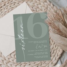 a close up of a card on top of a table with a plant and paper