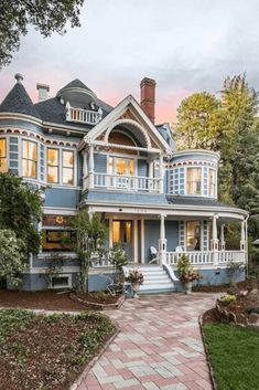 a large blue house sitting on top of a lush green field