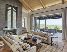 a living room filled with furniture and a fire place in front of a large window