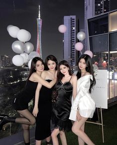 three beautiful young women standing next to each other in front of a cityscape