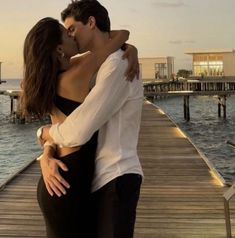 a man and woman embracing on a dock