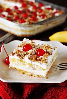 a piece of cake with cherries on top is sitting on a plate next to a fork