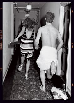 two people in towels are walking down the hallway