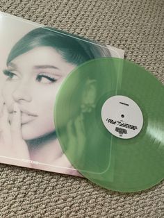 a green vinyl record sitting on top of a carpet