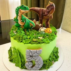 a birthday cake decorated with dinosaurs and eggs