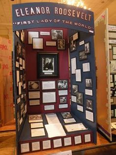 a display case filled with lots of framed pictures and papers on it's sides