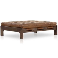 a brown leather ottoman sitting on top of a white floor next to a wooden frame