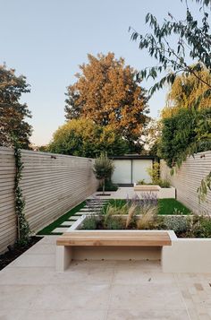 an outdoor garden with a wooden bench in the middle