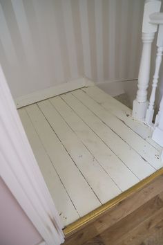 a white wooden floor next to a wall