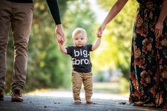 a little boy holding hands with his parents