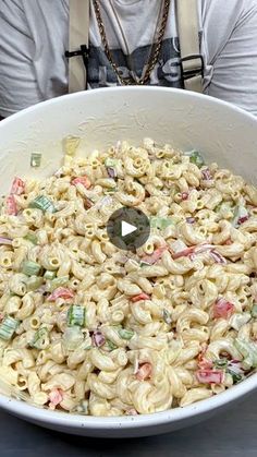 a man sitting in front of a large bowl of macaroni salad