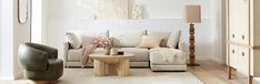 a living room filled with furniture and a white rug on top of a hard wood floor