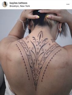 the back of a woman's neck with tattoos on her upper and lower part