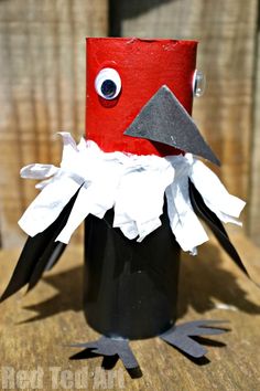 a toilet paper roll bird sitting on top of a wooden table