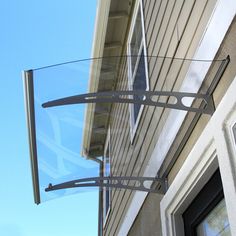 a window on the side of a house with a glass screen hanging from it's side