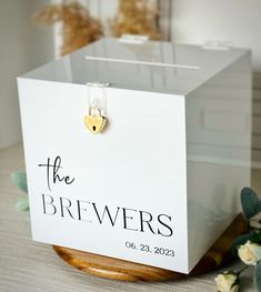 a small white box with a gold heart on it and the words the brewers written on it