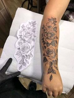 a woman's arm with flowers on it and a sticker next to her