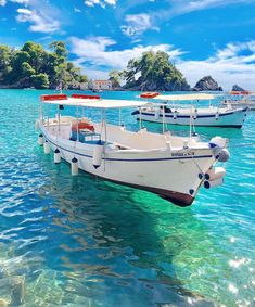 three boats are docked in the clear blue water