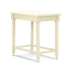 a small white table with beads on the legs