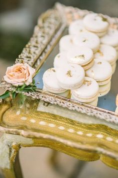 there is a tray with macaroons on it and a rose in the middle