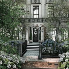 an artist's rendering of the entrance to a house with flowers and trees around it