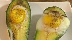 an avocado with two eggs in it on a plate