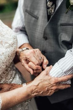 an older couple holding hands while standing next to each other