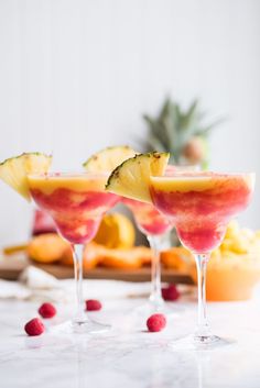 two glasses filled with watermelon, pineapple and raspberry martinis