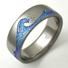 a wedding ring with an artistic design painted on the outside and inside, is shown