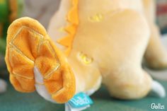 a close up of a stuffed animal with a tag on it's ear and other toys in the background