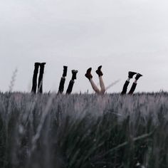 a person laying down in the grass with their feet up and arms out behind them