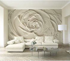 a living room with white furniture and a large wall mural