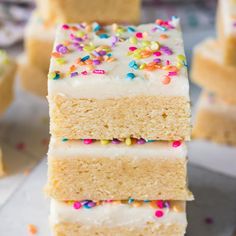 three pieces of cake with white frosting and sprinkles stacked on top of each other