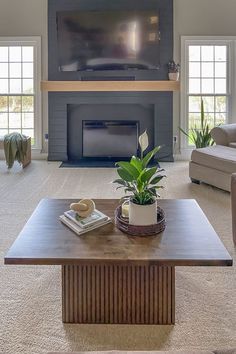 a living room with couches and a table in front of a tv on the wall