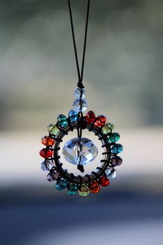 a multicolored beaded necklace hanging from a black cord