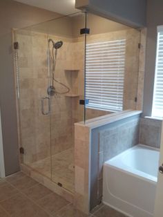 a bathroom with a walk in shower next to a bathtub