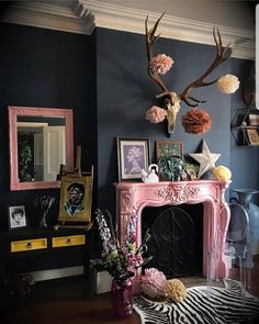 a living room with a pink fireplace and antlers on the wall