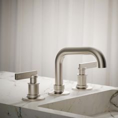 two faucets sitting on top of a marble counter