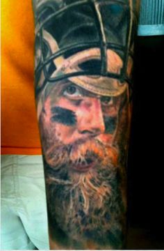 a man's arm with a tattoo on it and an image of a viking