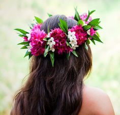 a woman with flowers in her hair wearing a flower crown on top of her head