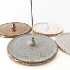 three plates and an umbrella on a white surface with one being held by a stick