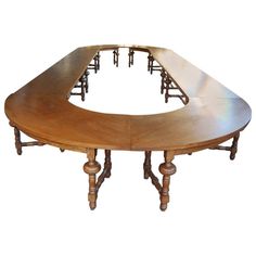 a wooden table with eight chairs around it and an oval shaped center piece on the top