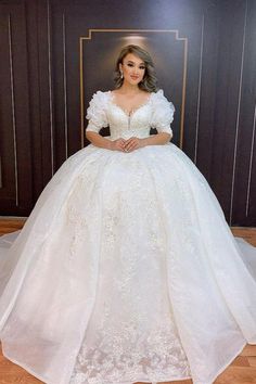 a woman in a white wedding dress posing for the camera